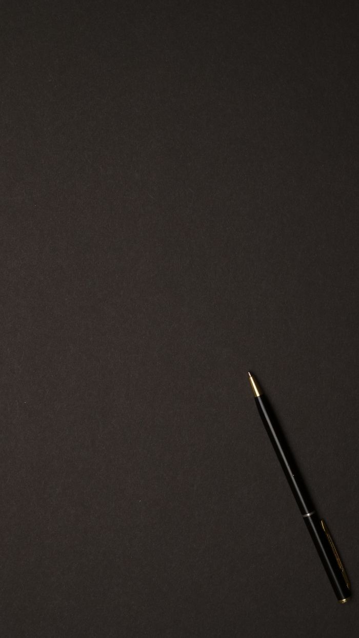 Sleek black pen on a dark background, offering ample copyspace for design purposes.